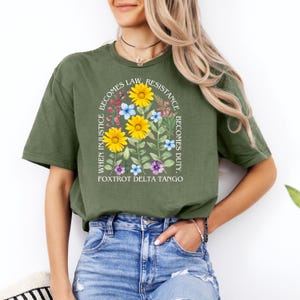 May include: Green t-shirt with a floral design and the text "When injustice becomes law, resistance becomes duty. Foxtrot Delta Tango."