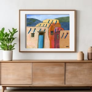 May include: A painting of a row of colorful adobe houses with blue doors and windows. The houses are set against a backdrop of green hills and a blue sky.
