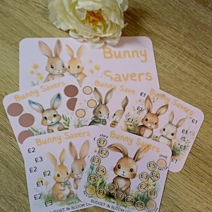 May include: A collection of square Bunny Savers savings challenge cards featuring illustrations of brown rabbits, yellow flowers, and circular spaces for tracking money. The cards display text including Bunny Savers, £1, £2, £3, £4, £5, and Budget in Bloom Designs.