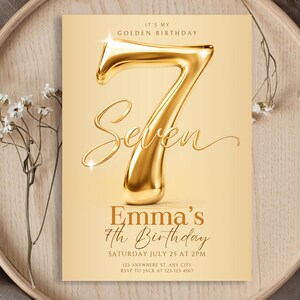 May include: A rectangular birthday invitation card featuring a large, metallic gold 3D number seven and the text IT'S MY GOLDEN BIRTHDAY, Seven, Emma's 7th Birthday, SATURDAY JULY 25 AT 2PM, 123 ANYWHERE ST, ANY CITY, RSVP TO JACK AT 123-123-4567.