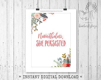 Puede incluir: Impresión blanca con la frase "Nevertheless, She Persisted" en escritura coral, adornada con diseños florales. La impresión está sujeta por una pinza negra sobre un fondo de madera blanca. El texto "Instant Digital Download" está en la parte inferior.