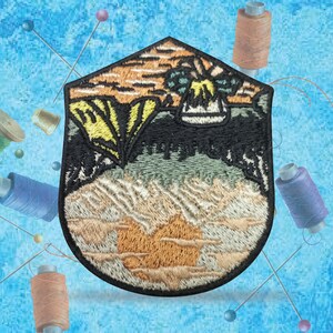 May include: Embroidered patch with a sunset scene, palm trees, and a beach. The patch is in shades of orange, yellow, green, and brown.