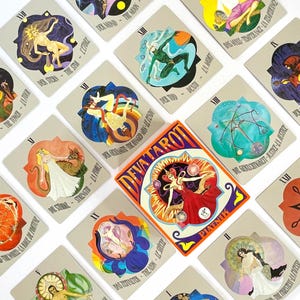 Könnte beinhalten: Ein Satz Tarotkarten mit farbenfrohen Illustrationen und Text. Die Karten zeigen Figuren, Himmelskörper und Symbole. Die zentrale Karte zeigt "DEVATAROT" und "PIATNIK". Die Karten sind auf einer weißen Oberfläche angeordnet.