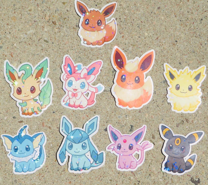 May include: A collection of colorful, glittery stickers featuring various cartoon creatures. The stickers showcase a variety of designs, including orange, yellow, blue, pink, and green characters with large eyes and unique features. These stickers are likely for decorating or collecting.