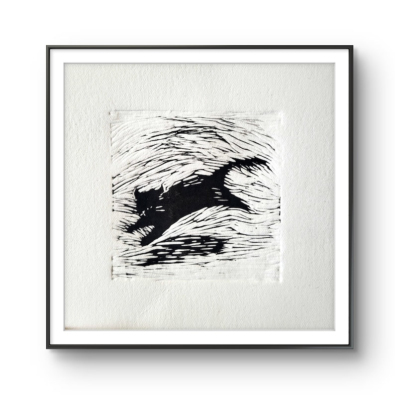 K&ouml;nnte beinhalten: Ein gerahmter Schwarz-Wei&szlig;-Linolschnitt eines sich bewegenden Katers. Das Kunstwerk zeigt eine stilisierte Silhouette einer Katze, die &uuml;ber einen strukturierten Hintergrund rennt. Der Druck ist in einem wei&szlig;en Passepartout und einem schwarzen Rahmen gefasst.