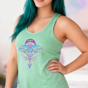 May include: A light green tank top with a colorful moth graphic. The moth design features shades of blue, purple, and yellow, with a crescent moon and sun design above it. The tank top is a scoop neck style.