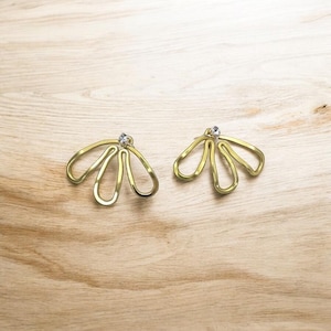 May include: A pair of gold earrings with a delicate, abstract design. Each earring features a cluster of five curved, open loops, with a small clear rhinestone at the center.