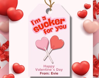May include: A pink and white Valentine's Day gift tag with the text "I'm a sucker for you" and two pink and red heart-shaped lollipops. The tag also says "Happy Valentine's Day From: Evie".