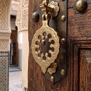 May include: A white ceramic mug with a black handle and the text "But First, Coffee" in a black, handwritten-style font. The mug is on a white surface.