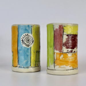 May include: A set of three ceramic vases in varying heights and shapes. The vases are glazed in a matte white finish, offering a minimalist aesthetic. The tallest vase is approximately 10 inches high.