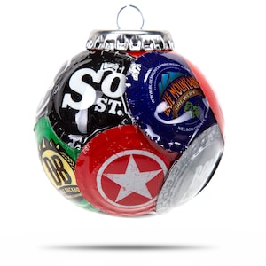 Puede incluir: Un adorno navideño hecho de varias tapas de botellas de cerveza. El adorno es rojo, verde, plateado y negro. Las tapas presentan logotipos y texto, incluyendo "So. St." y "Blue Mountain Brewery".