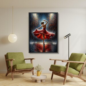 May include: A framed art print showing a ballerina in a red dress dancing in the rain. The artwork has a dark background with blue and gold highlights, and a reflective surface. The dancer's pose is graceful and dynamic, creating a sense of movement.