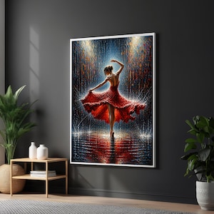 May include: A framed print shows a dancer in a red dress, captured mid-spin, with arms extended. The background has a rain-like effect with blue and gold hues, creating a dramatic scene. The artwork is displayed on a dark grey wall.