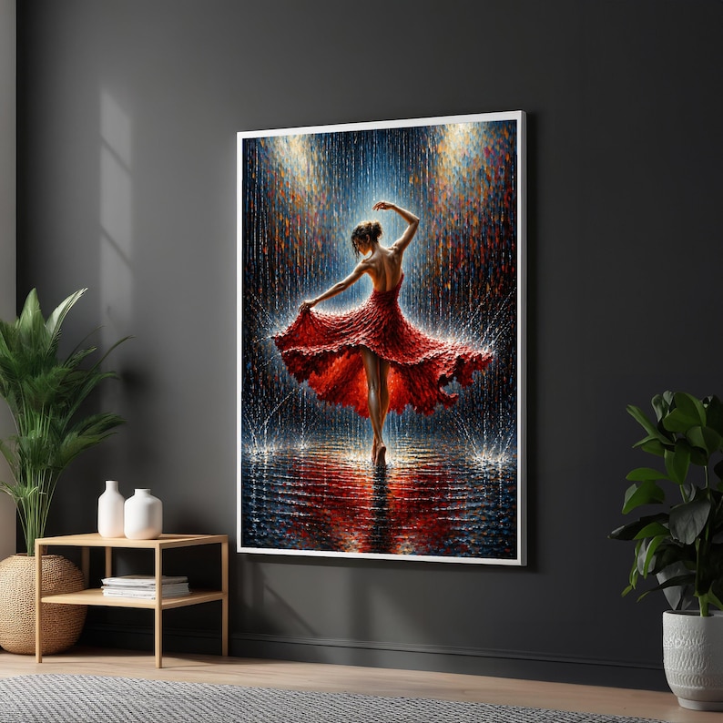 May include: A framed print shows a dancer in a red dress, captured mid-spin, with arms extended. The background has a rain-like effect with blue and gold hues, creating a dramatic scene. The artwork is displayed on a dark grey wall.