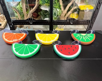 Peut inclure: Ensemble de cinq mangeoires pour reptiles en forme de fruits colorés. Les mangeoires ressemblent à des tranches d'orange, de citron, de kiwi, de citron vert et de pastèque. Chaque mangeoire est équipée d'une ventouse.