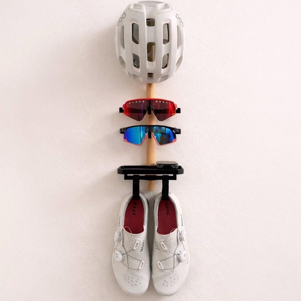 An der Wand befestigter Rad- und Lauforganizer. Helmhaken, Sonnenbrillenhalter und Schuhregal