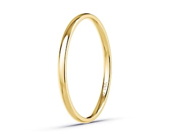 May include: A slender, polished gold ring, likely 14K, against a white background. The ring is a simple band, showcasing a smooth, reflective surface. The minimalist design highlights the ring's elegant simplicity.