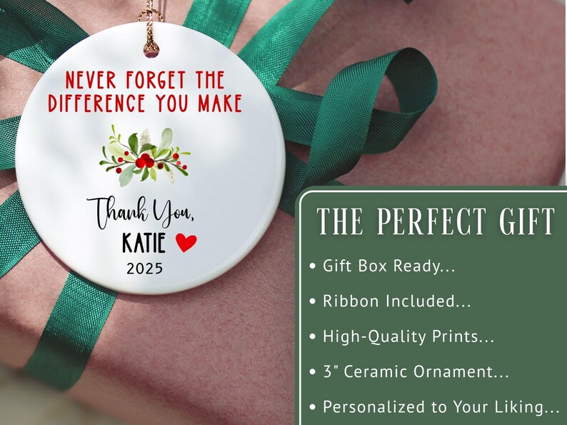 May include: A white ceramic ornament with the text "NEVER FORGET THE DIFFERENCE YOU MAKE" and "Thank You, KATIE 2025". The ornament has a floral design and a red heart. The ornament is approximately 7.6 cm in diameter.