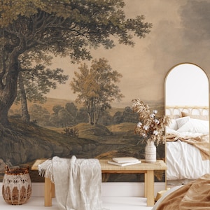 May include: A bedroom interior featuring a large wall mural depicting a landscape scene with trees and a cloudy sky. The mural is in shades of brown, green, and beige. A wooden bench with a white blanket sits in front of the mural. A wicker basket and a vase with dried flowers are on the floor. A bed with white and brown bedding is in the foreground.