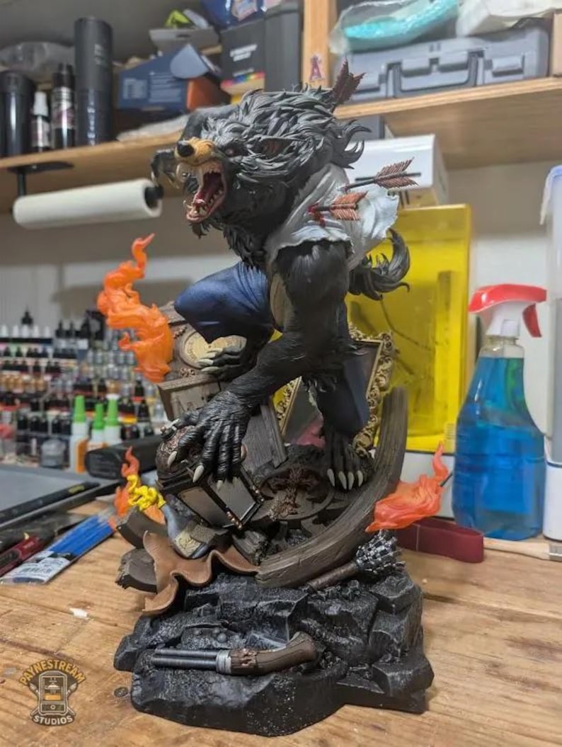 May include: A detailed figurine of a werewolf in a dynamic pose, with a snarling expression and claws extended. The figure is dark gray with blue pants and a torn white shirt, pierced by arrows. Orange flames and a broken frame add to the dramatic scene.