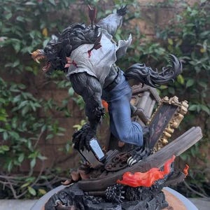 May include: A detailed werewolf figurine with dark fur, wearing a torn white shirt and blue jeans, featuring arrows embedded in the back. The figure stands on a debris-filled base with a broken picture frame and orange flames, marked with a Paynestream Studios logo.