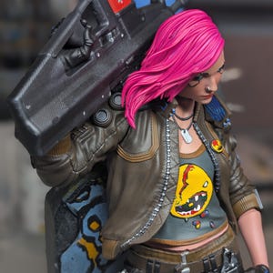 May include: A collectible figurine of a character with bright pink hair, wearing a brown leather jacket over a gray shirt with a yellow graphic, black pants, and a chain. The character carries a large black rifle with a red top section.