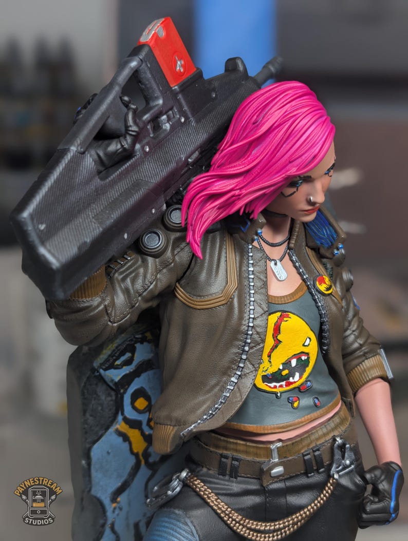 May include: A collectible figurine of a character with bright pink hair, wearing a brown leather jacket over a gray shirt with a yellow graphic, black pants, and a chain. The character carries a large black rifle with a red top section.