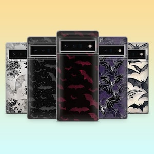 May include: Five phone cases with bat patterns. Designs include black and white floral, black bats on black, red bats on black, purple bats, and black bats on white. The cases are for a mobile phone.