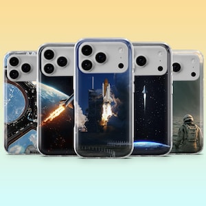 May include: A collection of clear phone cases featuring space-themed designs. The cases showcase images of a rocket launch, a spacecraft in space, and an astronaut. The cases have a clear border and a glossy finish.