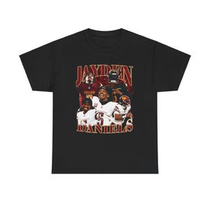 May include: Black t-shirt featuring a vintage-style graphic of football players. The graphic includes the text "Jayden Daniels" and depicts several players in red and gold uniforms.
