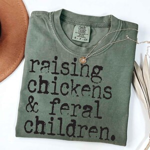 Funny rustic motherhood sublimation design with chickens and playful text “Raising Chickens & Feral Children” in a vintage farm style
