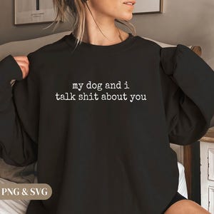 May include: Black sweatshirt with the text "my dog and i talk shit about you" in white. The sweatshirt is a crew neck style. The image also includes the text "PNG & SVG" in the bottom left corner.