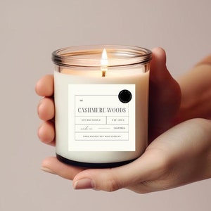 May include: A clear glass candle jar with a white label that reads "CASHMERE WOODS" Soy Wax Candle 9 oz | 255 g Made in California Hand Poured Soy Wax Candles.