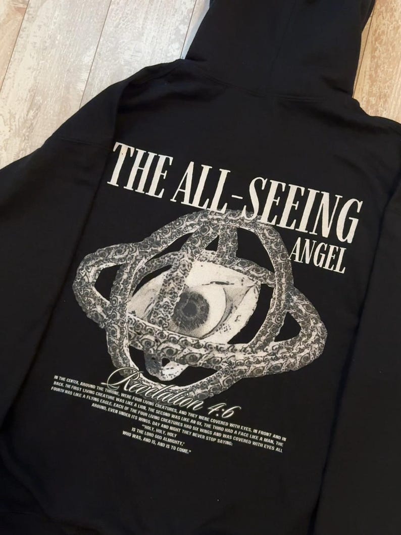 May include: Black hoodie with the text "THE ALL-SEEING ANGEL" and a graphic of an eye within a circular design. The text "Revelation 4:6" is below the graphic, along with a Bible verse.