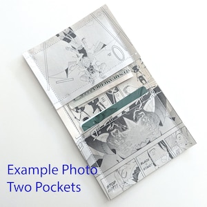 Puede incluir: Una cartera hecha de un c&oacute;mic con dos bolsillos. La cartera tiene un dise&ntilde;o de c&oacute;mic en blanco y negro con una tarjeta verde dentro de uno de los bolsillos. El texto "STOP!!" y "BLACK STAR!!" es visible en la cartera.