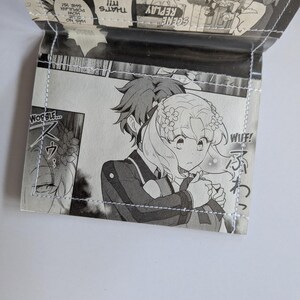 Puede incluir: Un panel de manga en blanco y negro con dos personajes. El personaje femenino tiene el pelo largo y ondulado y lleva un vestido blanco con un dise&ntilde;o floral. El personaje masculino tiene el pelo corto y puntiagudo y lleva un traje oscuro. El texto en el panel dice "WIIF!" y "WOBBLE..."