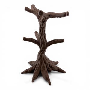 May include: A dark brown, tree-shaped stand with a textured, bark-like surface. The object features a central trunk that branches out into multiple arms at two different levels, supported by a wide, root-like base that provides stability.
