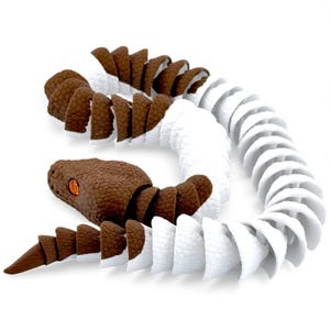May include: A segmented articulated snake toy featuring a repeating pattern of brown and white textured scales. The snake has a brown head with bright orange eyes and a long, flexible body composed of individual interlocking plastic pieces.