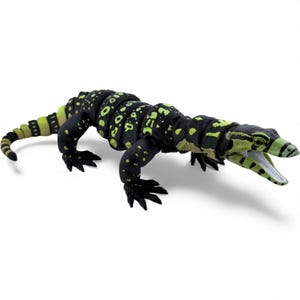 May include: An articulated lizard figurine featuring a black base color with vibrant lime green spots and stripes. The reptile has a segmented body, four clawed feet, and an open mouth showing a white interior, designed with a flexible structure.