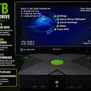 May include: A black original Xbox console with a green logo, displayed in front of an Emerson monitor showing a system dashboard. Text on the screen includes 2TB HARD DRIVE, Settings, Game Saves Manager, Clock Settings, Skins, and Copy DVD.
