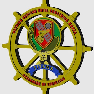 May include: A gold-colored ship's wheel design with the text "NOTHING HAPPENS UNTIL SOMETHING MOVES" in red. The center features a shield with a train, anchor, and other symbols, and the word "TITANS" on a blue banner.
