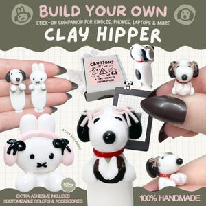 Op de afbeelding: Handgemaakte kleifiguren van honden en konijnen, met zwarte en witte details en roze accenten. De tekst "BUILD YOUR OWN CLAY HIPPER" en "100% HANDMADE" zijn zichtbaar. De figuren zijn ontworpen als stick-on companions.