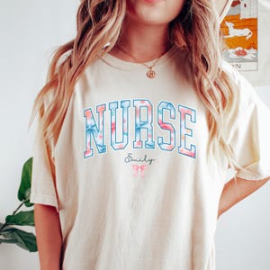 Comfort Colors Nurse Bow Shirt, Floral Varsity Nurse Tee, Custom Name RN T‑Shirt, Nursing School Shirt, Nurse Appreciation Gift, RN Shirt