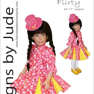 以下が含まれることがあります： ピンクと白の花柄のドレスに黄色のスカートとピンクの帽子をかぶった人形。人形は白いタイツと黄色の靴を履いています。人形の身長は28cmです。このパターンは「Flirty」と呼ばれ、Tamara Caseyによってデザインされました。