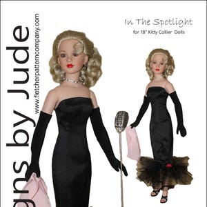 Pode incluir: Uma boneca vestindo um vestido preto sem alças, luvas longas pretas e uma saia de tule. A boneca tem cabelo loiro e batom vermelho. A imagem é rotulada como "In The Spotlight" e "Designs by Jude".