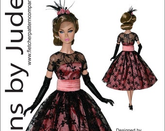 Puede incluir: Un vestido de encaje negro y rosa con una faja de satén rosa para una muñeca Poppy Parker de 31,75 cm. El vestido está diseñado por Tamara Casey. El precio es de 12,95 $ US.