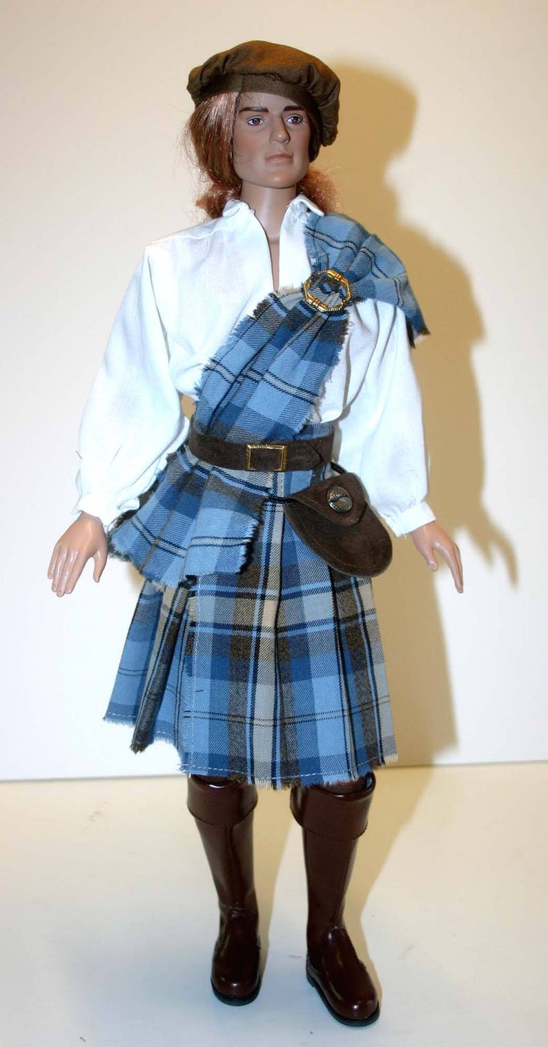 May include: A doll wearing a blue and white plaid kilt, a white shirt, a brown belt, a brown hat, and brown boots.