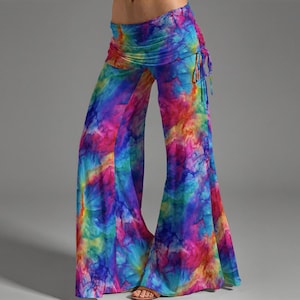 Może przedstawiać: Kolorowe spodnie palazzo w stylu tie-dye z szerokimi nogawkami. Spodnie mają żywą mieszankę kolorów, w tym niebieski, różowy, żółty i pomarańczowy. Talia ma marszczony detal ze sznurkiem. Spodnie wykonane są z miękkiej, zwiewnej tkaniny.