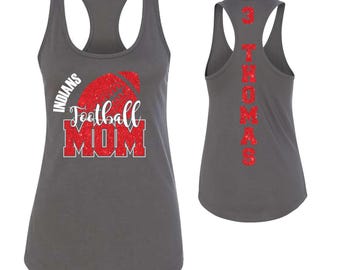 May include: Grey racerback vest top with the words "INDIANS Football MOM" in white and red glitter. The back of the vest top has the name "3 THOMAS" in red glitter. A sporty top for football fans.