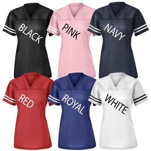 May include: Six mesh V-neck jerseys in black, pink, navy, red, royal blue, and white. Each jersey has white stripes on the sleeves and the color name printed across the front in white.